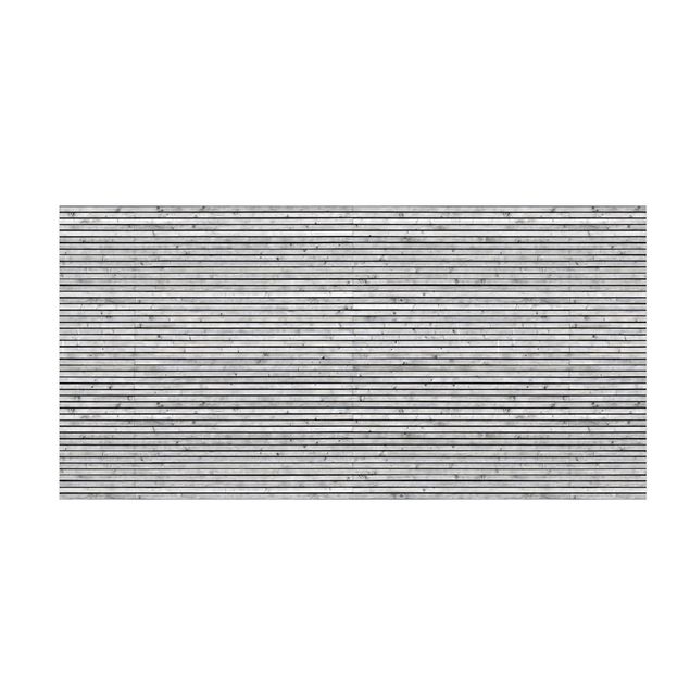 Grauer Teppich Holzwand mit schmalen Leisten schwarz weiß