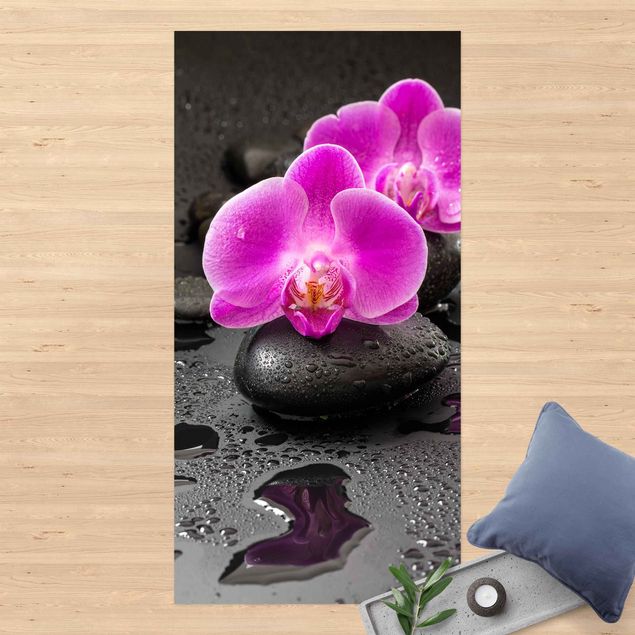 Läufer Pinke Orchideenblüten auf Steinen mit Tropfen
