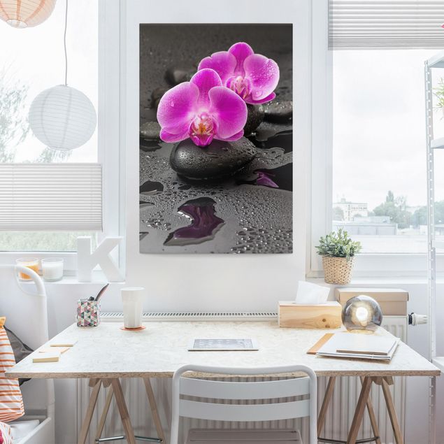 Leinwandbild - Pinke Orchideenblüten auf Steinen mit Tropfen - Hochformat 3:2