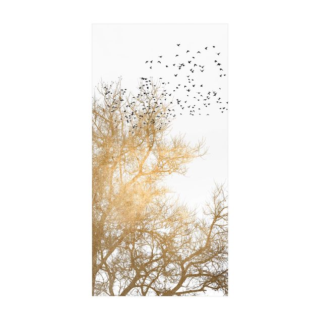 Goldener Teppich Vogelschwarm vor goldenem Baum